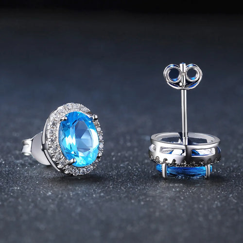 925 sterling silver geometric jewellery set with blue topaz gems showing earrings, ring, necklace, and pendant