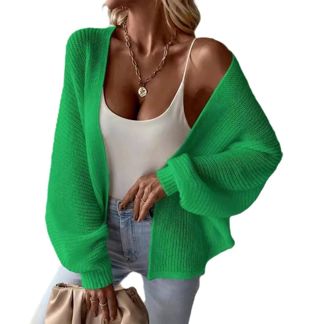 Loose-fitting women's cardigan with batwing sleeves in a solid colour, shown on a model.