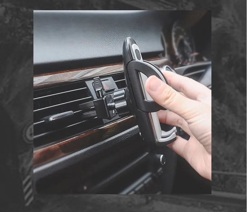 Black plastic mobile phone holder mounted on car air conditioning vent with phone in cradle