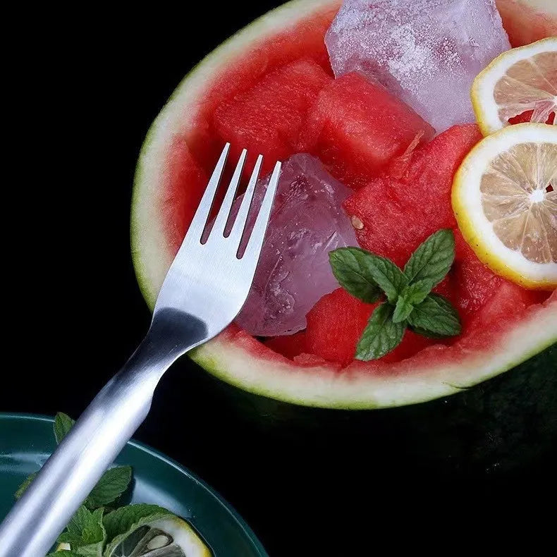 Silver stainless steel watermelon slicer and serving fork on a kitchen counter