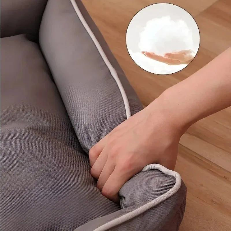 Gray luxury dog sofa bed with raised edges on a wooden floor, showing waterproof Oxford cloth and plush cushion.