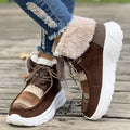 Beige women's lace-up suede mid-top snow boots with a thick sole on a winter background.
