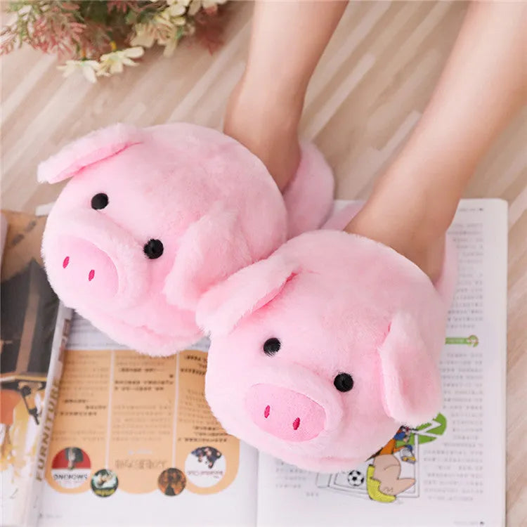 Pink pig-shaped plush floor slippers with a soft, textured surface and cushioned sole.