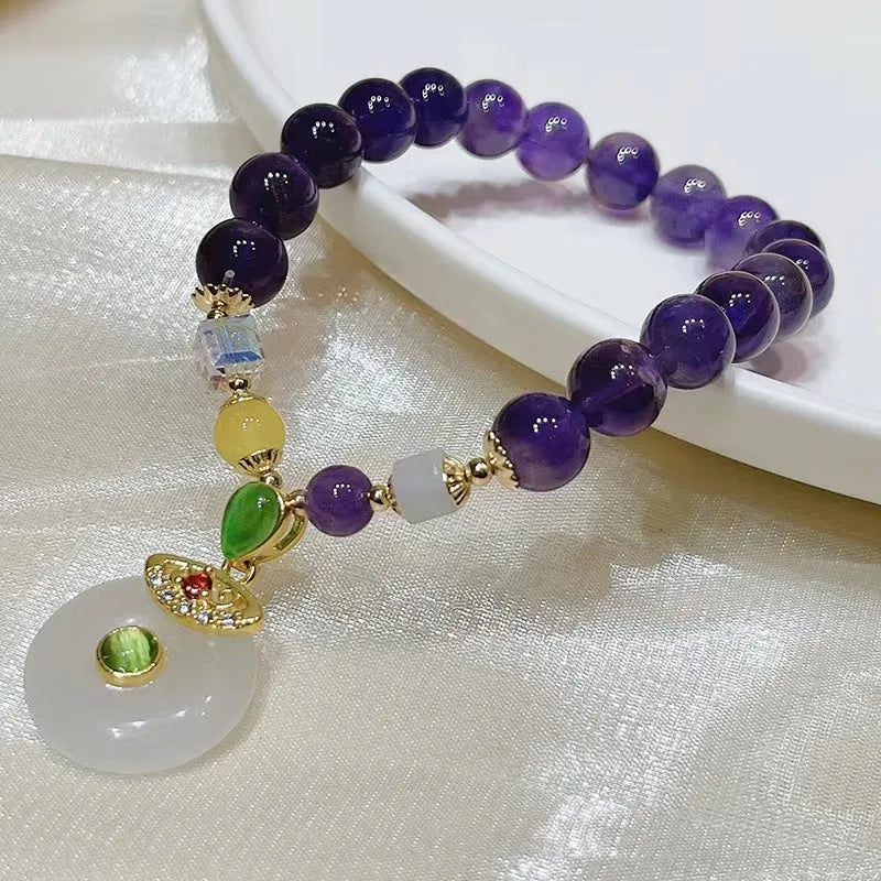 Purple amethyst bracelet with ethnic-style money bag pendant and geometric shapes on wrist