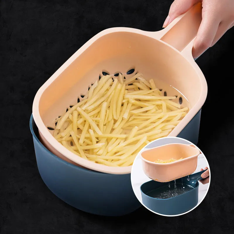 Dark blue vegetable cutter with four stainless steel blades, drain basket, and hand protection guard on kitchen counter