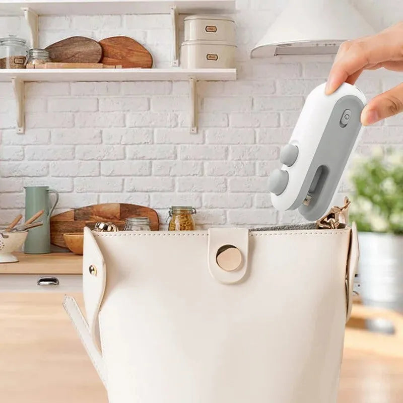 Blue and white handheld USB rechargeable heat sealer for sealing chip bags and food storage packets.