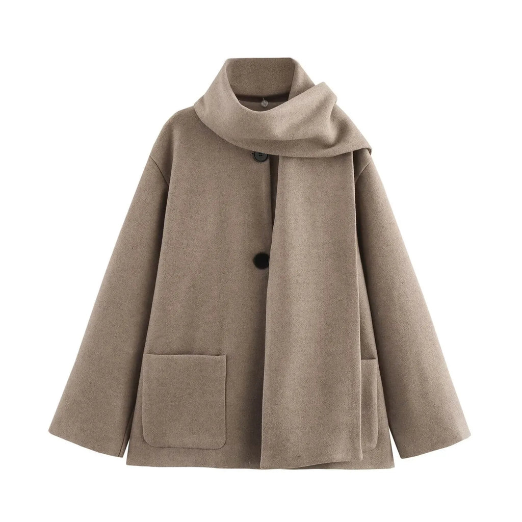 A woman wearing a long grey polyester coat with a detachable artificial fur collar and side pockets.