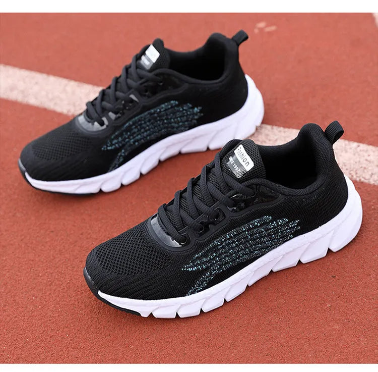 Women's black and white running shoes with cross strap detail and MD shock absorption sole