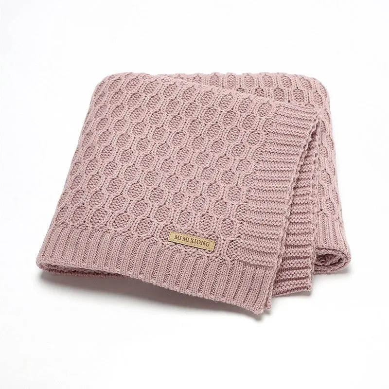 Solid colour acrylic infant blanket with textured lines, shown in a choice of five colours.