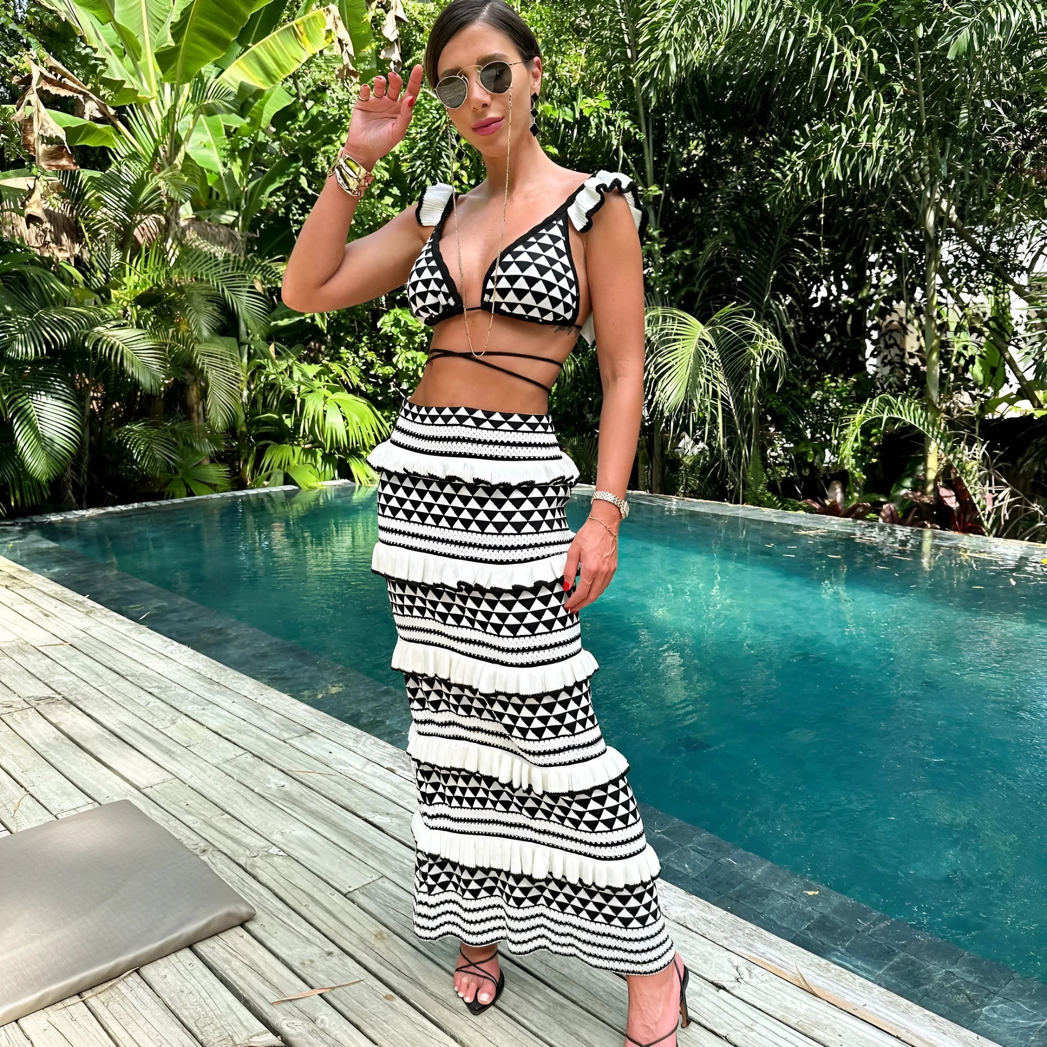 Black and white striped ruffled bikini top with spaghetti straps paired with a long knitted skirt.