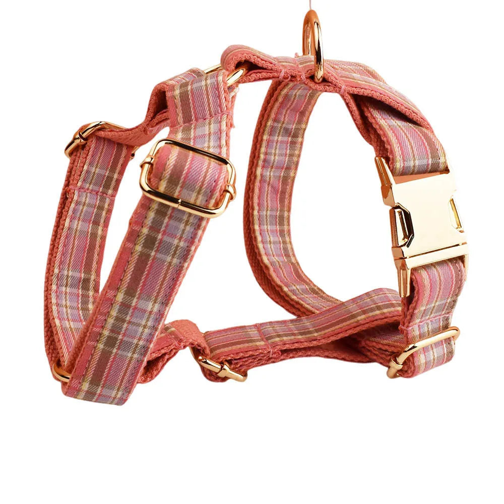 Plaid cloth fabric dog collar, vest, bow tie, and leash set laid out flat.