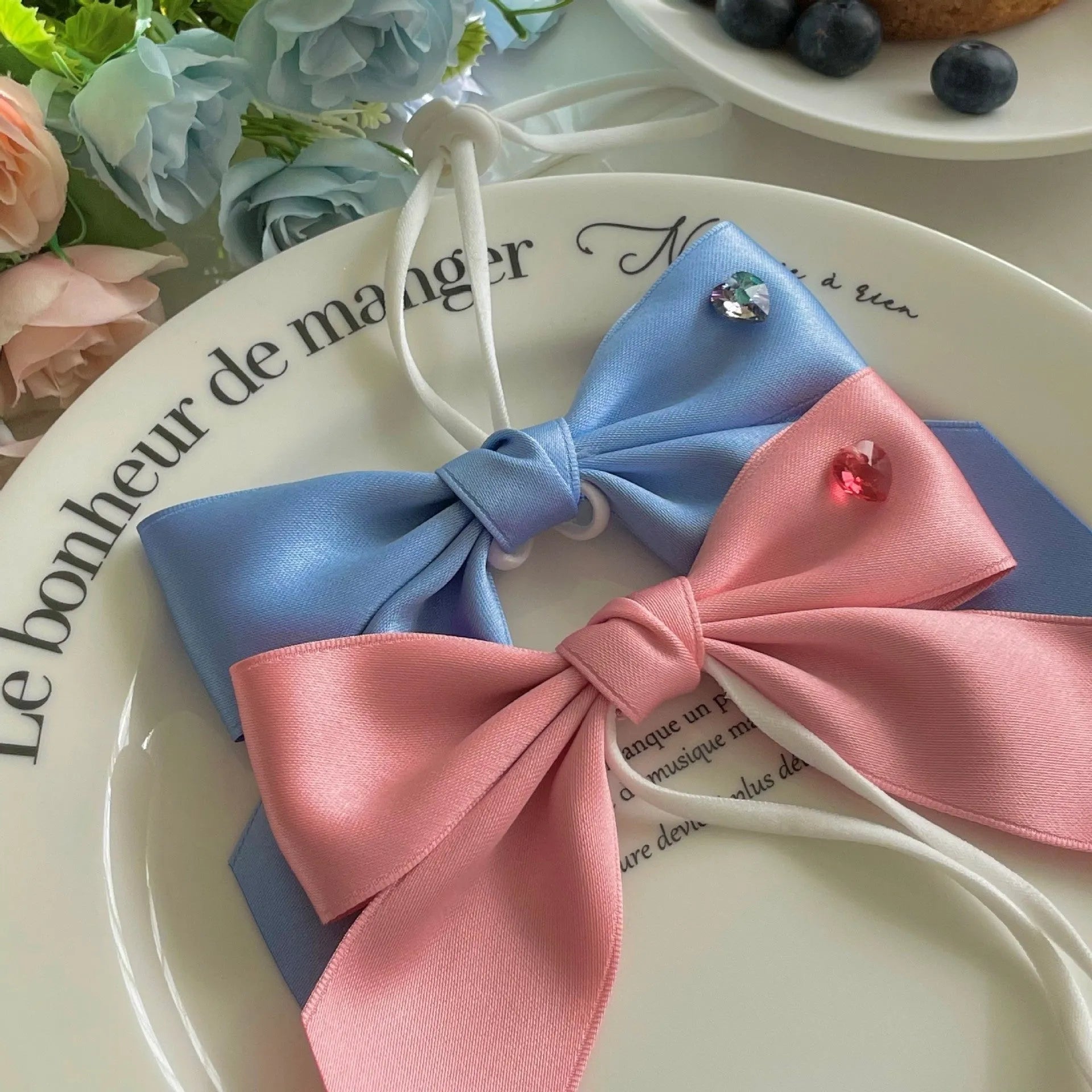 Princess style blue bow dog hair band with adjustable fit on a small dog.