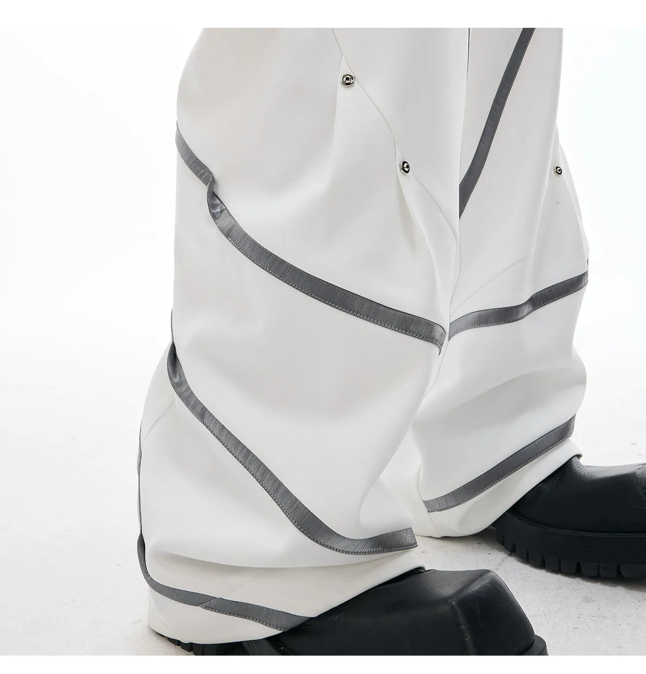 Men's black trousers with three-dimensional cut, metal striped rivets, and pleated detailing