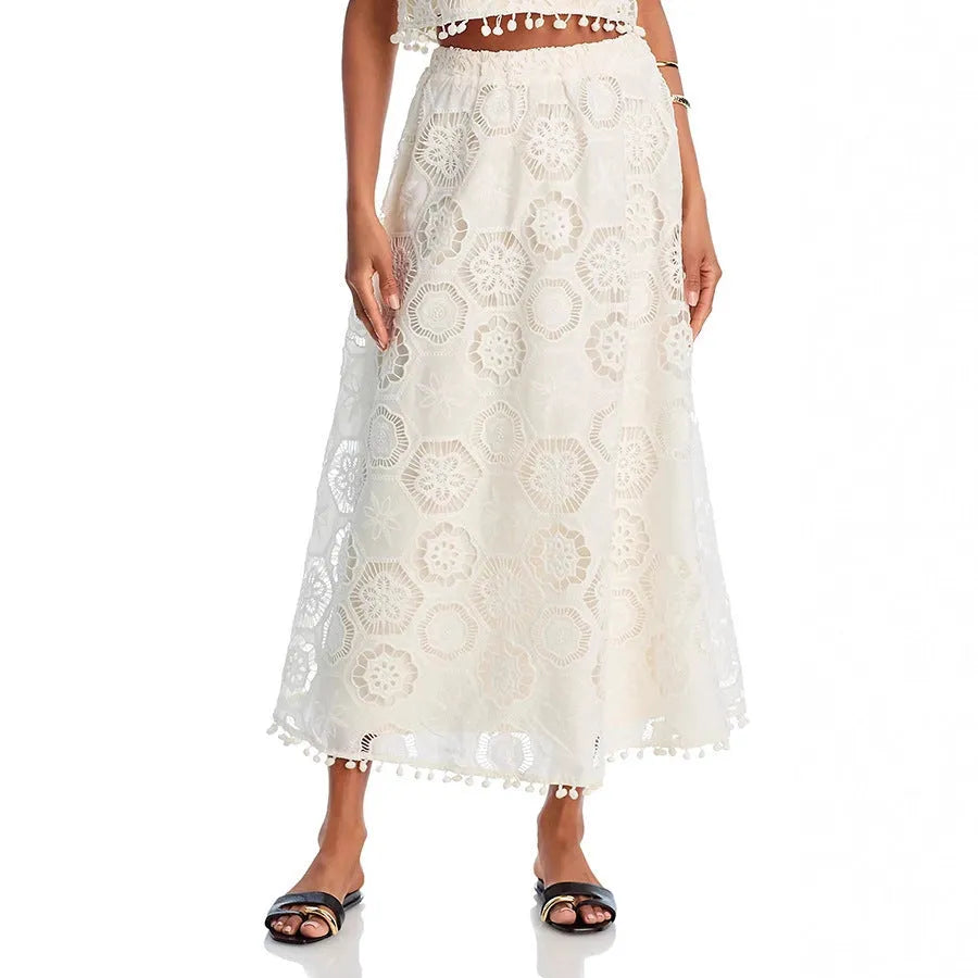 White women's sleeveless top and embroidered long skirt suit set on a hanger.