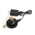 Black silicone rechargeable hearing aid amplifier for elderly users on a charging cable.