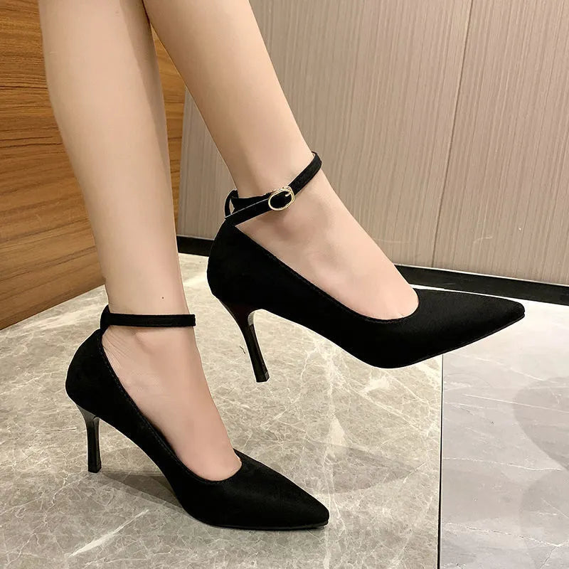 Black and creamy white women's stiletto heel pumps with buckle closure and skull pattern.