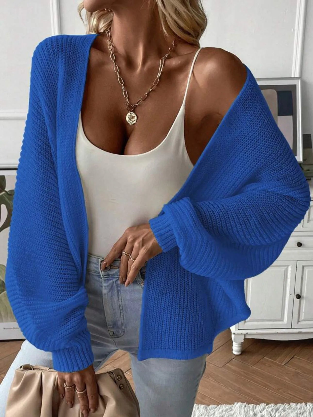 Loose-fitting women's cardigan with batwing sleeves in a solid colour, shown on a model.