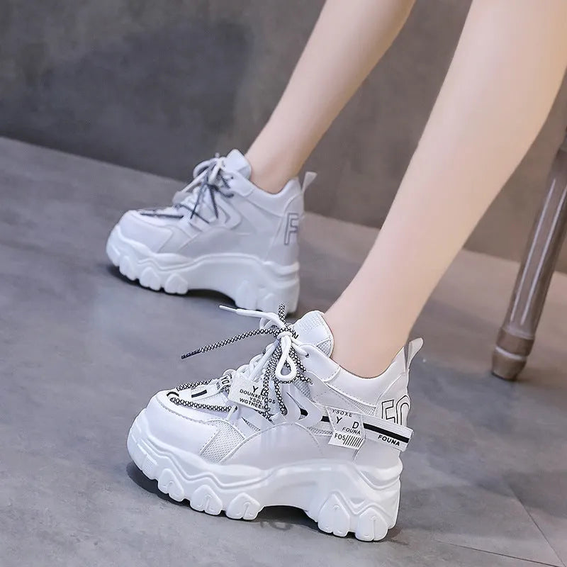 White and black women's low-top platform sports shoes with a cross strap and mesh upper.