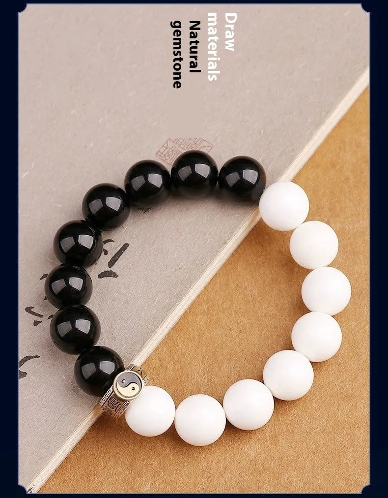 Black and white Taiji symbol bracelet made from obsidian beads with engraved mantra.