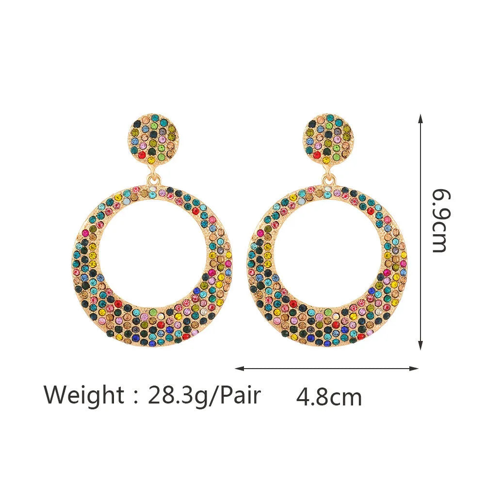 A pair of large round cartoon-style pendant earrings with coloured rhinestones on alloy metal.