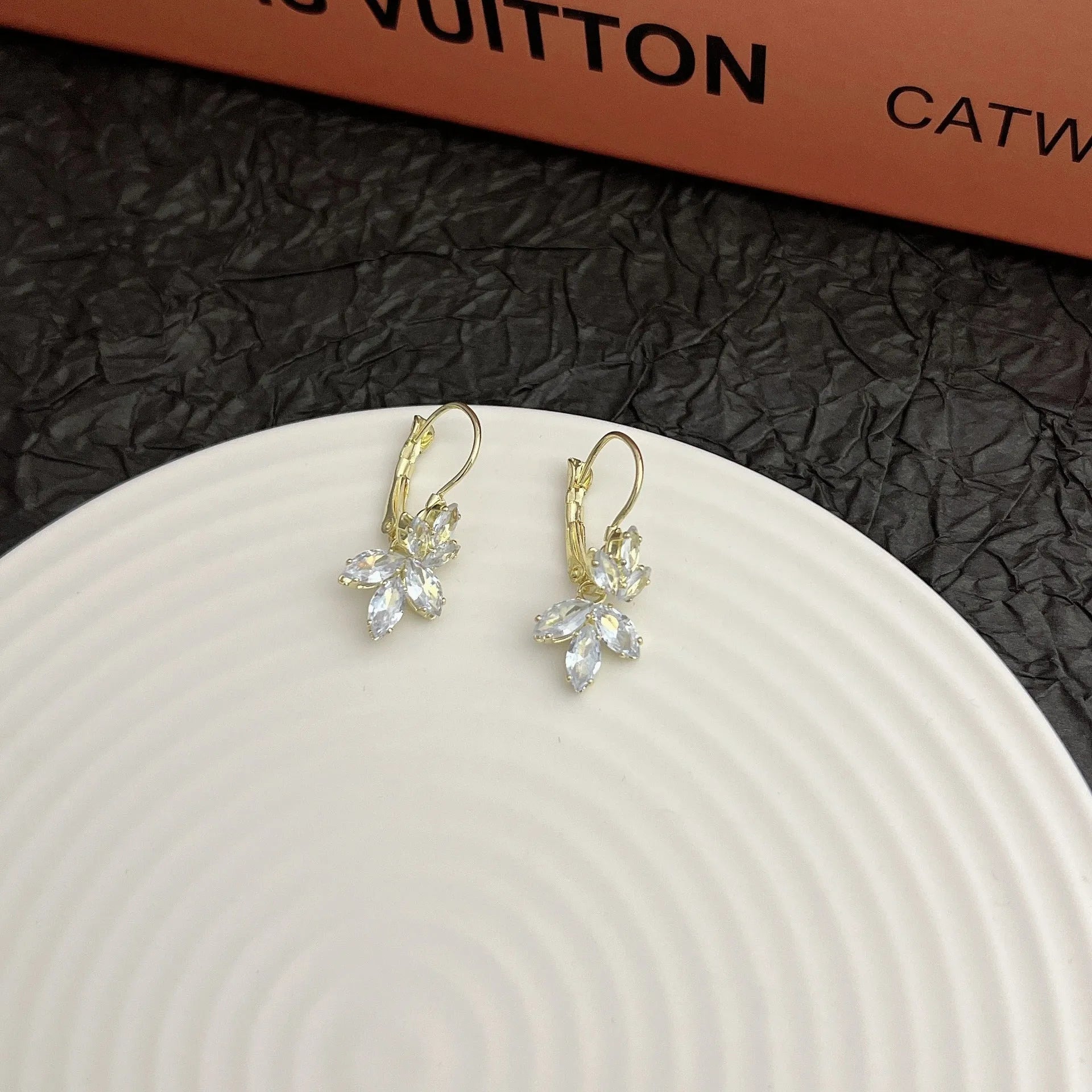 Platinum colour alloy earrings with leaves shape design featuring inlaid zircon stones