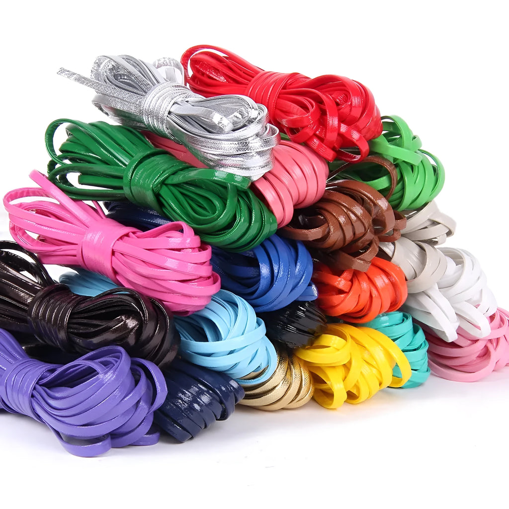 Spool of beige PU leather woven cord next to samples in black, red, and blue colours
