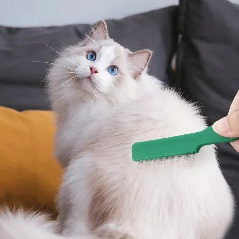 Green plastic-handled flea comb with stainless steel pins for dogs and cats.