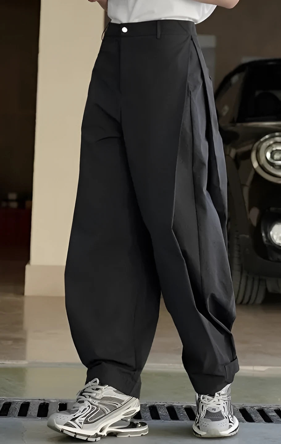 Black high-waisted women's trousers with front pleats and a loose wide-leg silhouette.