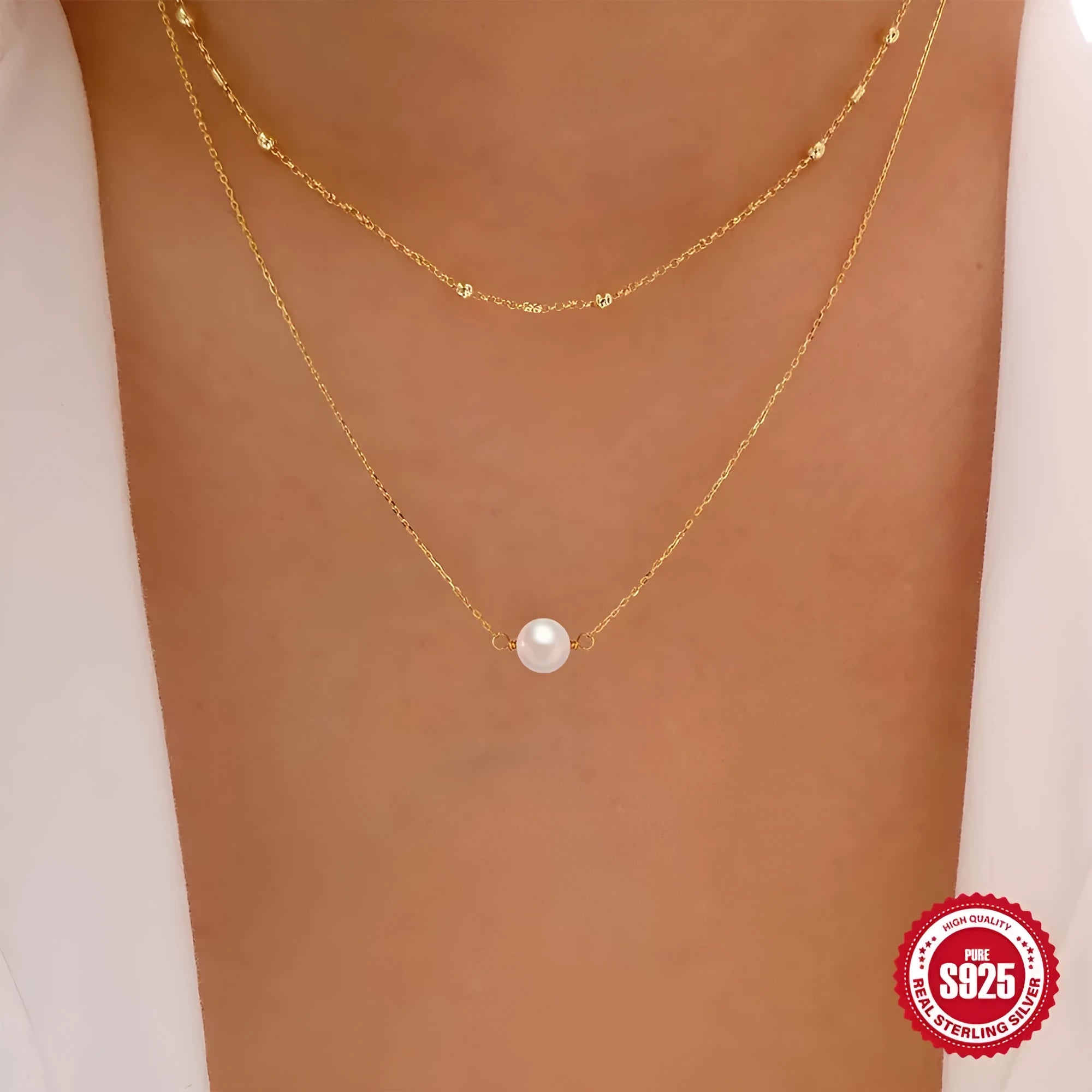 Close-up of a women's double layer sterling silver necklace with two round freshwater pearls on a geometric pendant.