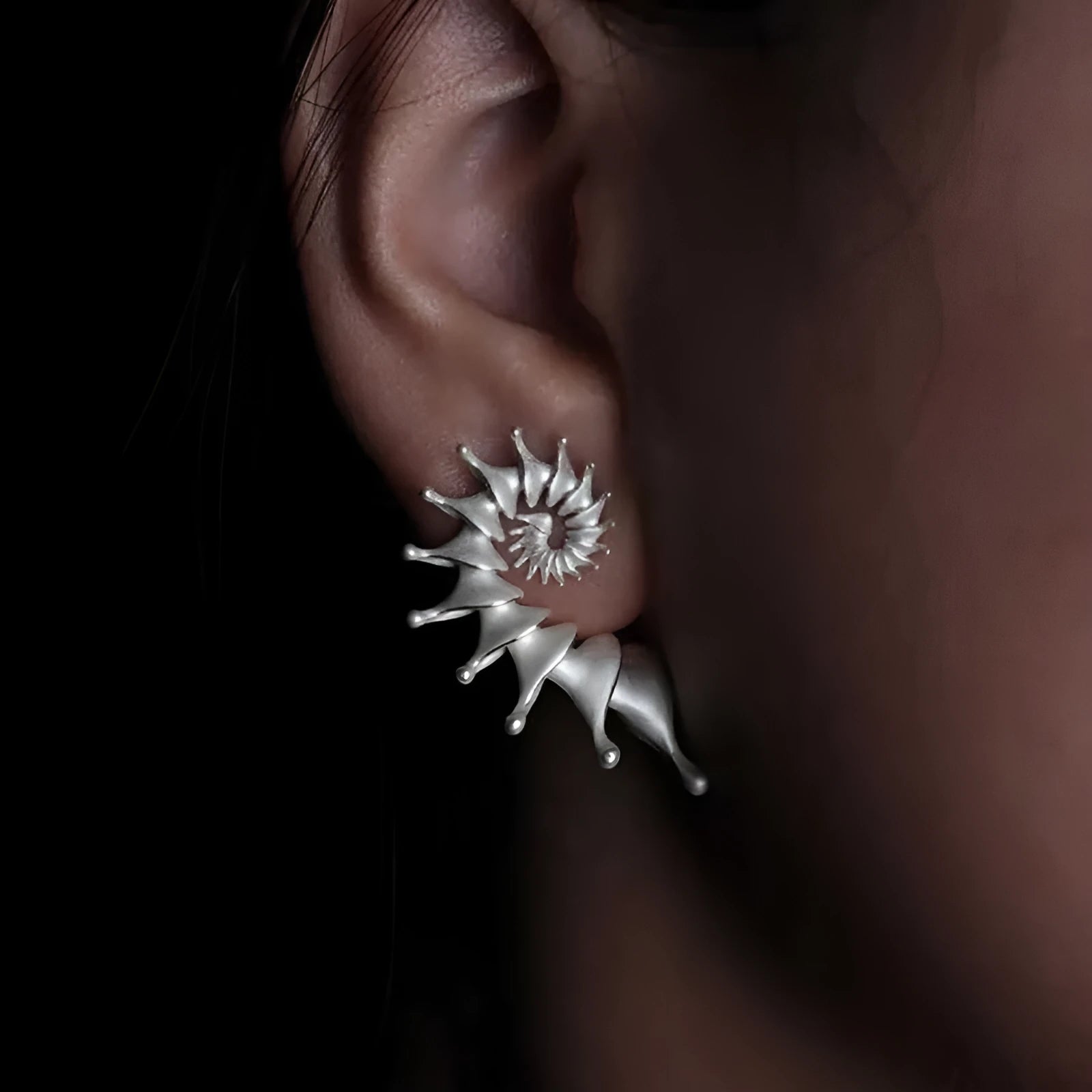 A pair of matte finish conch-coloured alloy stud earrings with a three-dimensional irregular shape.