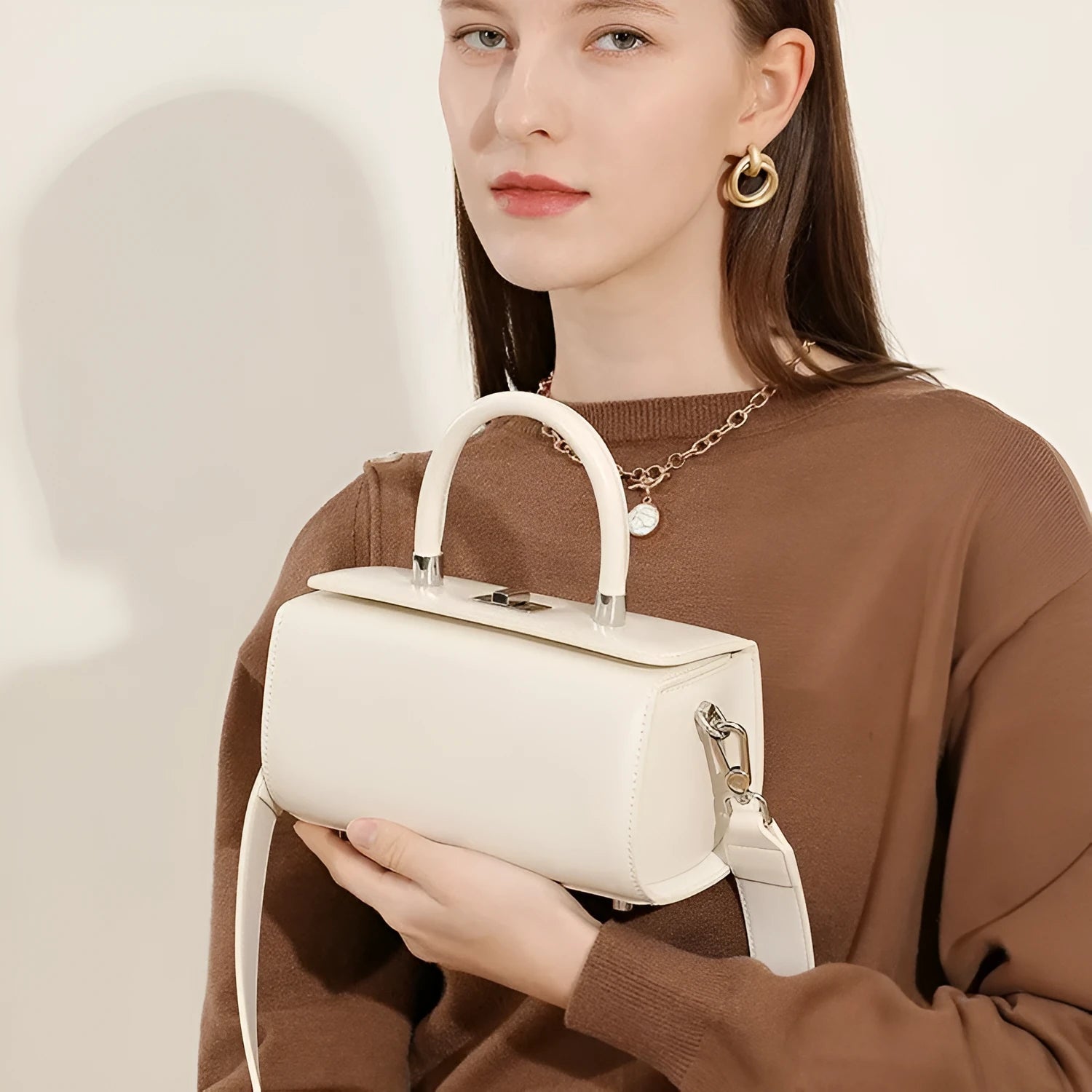 Women's black cowhide leather one-shoulder crossbody bag with clamshell opening, shown closed.