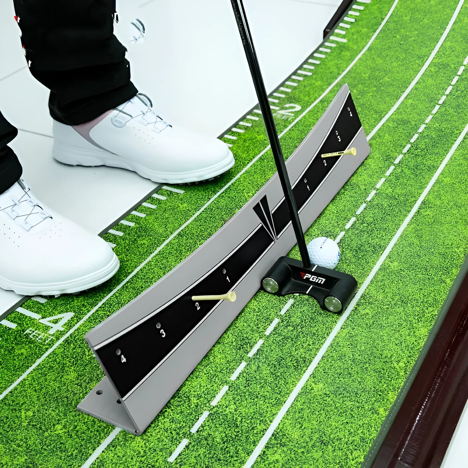 Close-up of an adjustable PVC golf putter trajectory balance simulator on a flat surface.