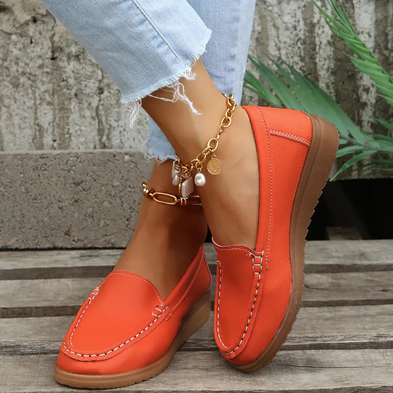 Women's flat PU leather loafers in multiple colours showing round toe and car suture detail.