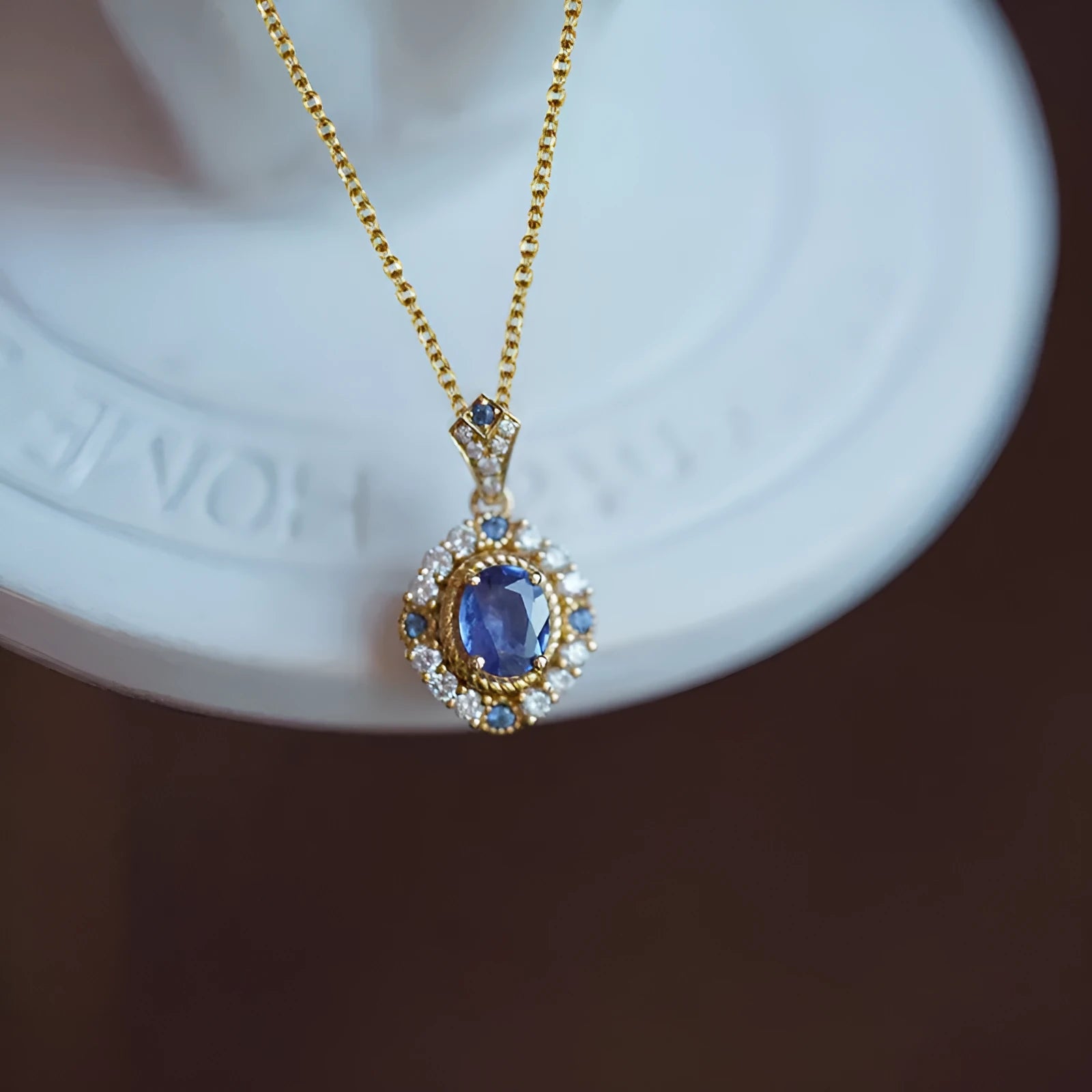 Golden women's necklace with a sparkling zircon inlaid gemstone pendant on an adjustable box chain.
