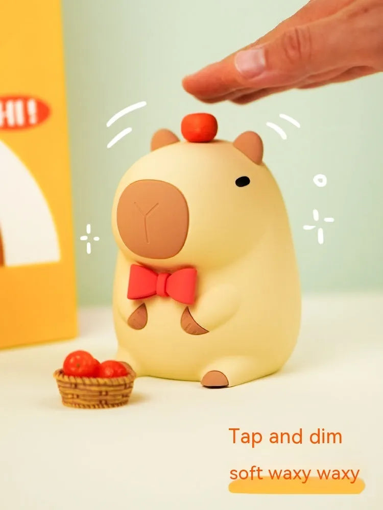 Small grey capybara-shaped silicone night lamp on a table.