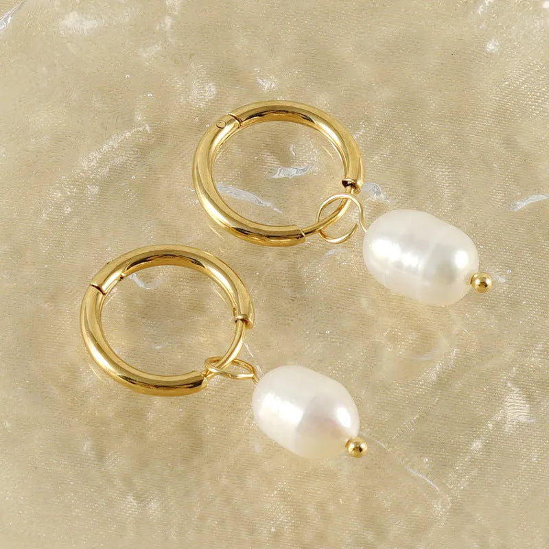 Gold geometric stainless steel earrings with a central white cultured pearl on a post.