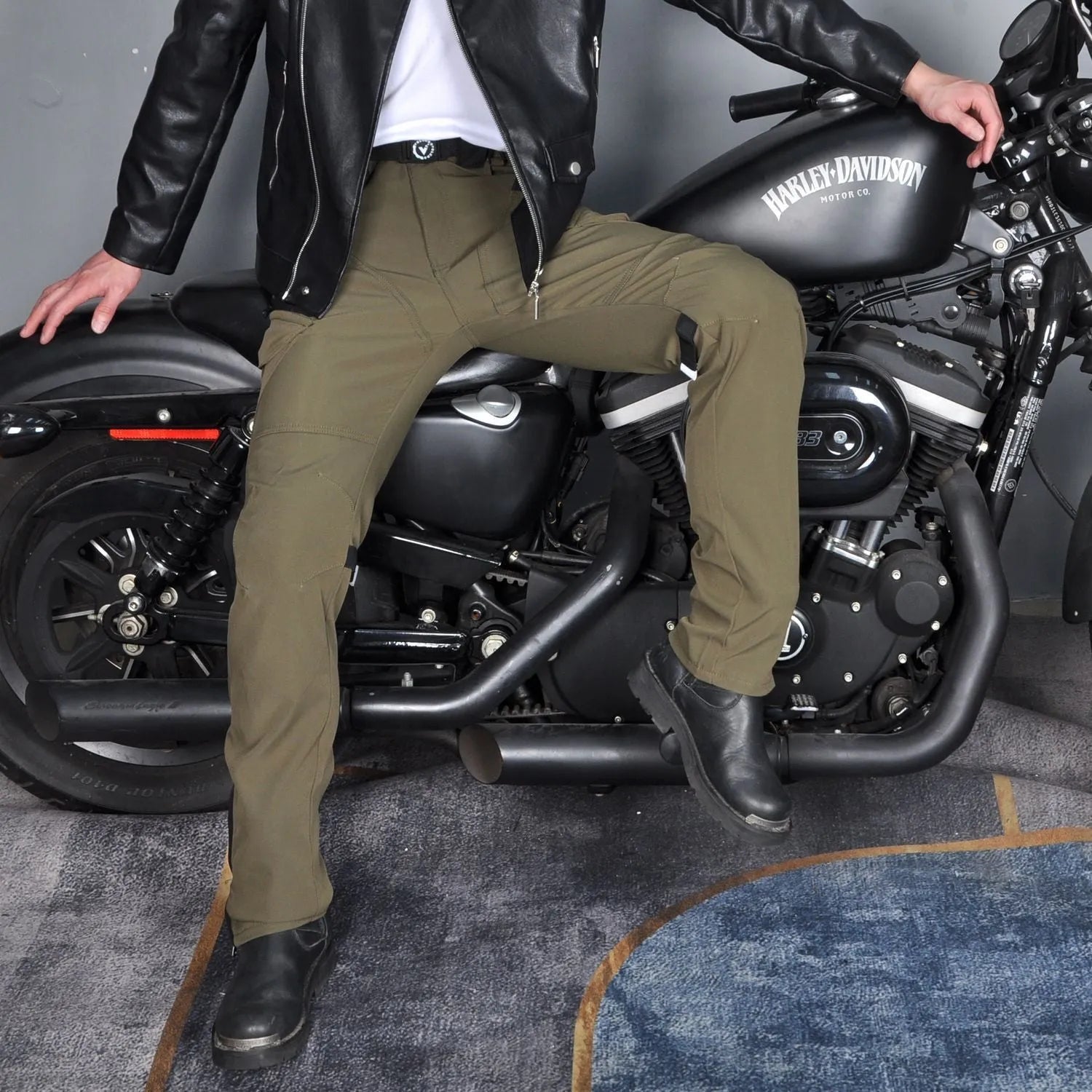 Men's solid green waterproof motorcycle cycling pants laid flat, showing belt and protective gear set.