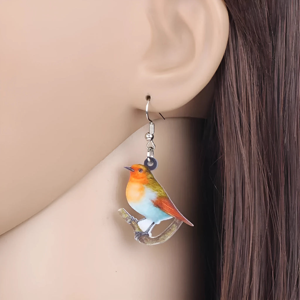 Close-up of blue titmouse and snake geometric design on women's acrylic pendant earrings.