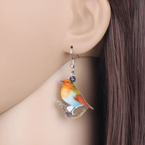 Close-up of blue titmouse and snake geometric design on women's acrylic pendant earrings.