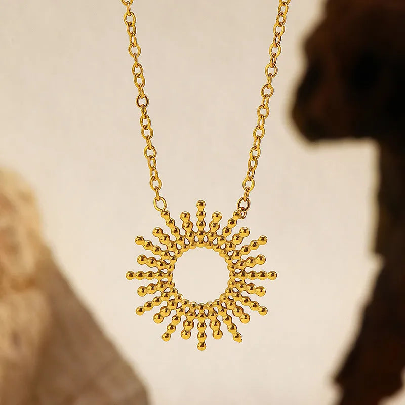 Gold geometric chain necklace and matching bracelet set on a plain background.