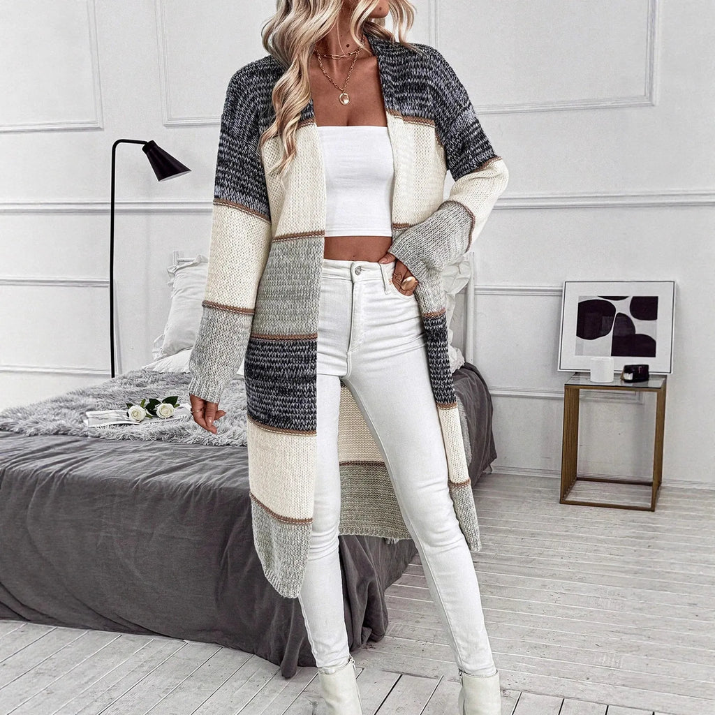Grey women's knitted long cardigan with loose fit and long sleeves on a hanger.