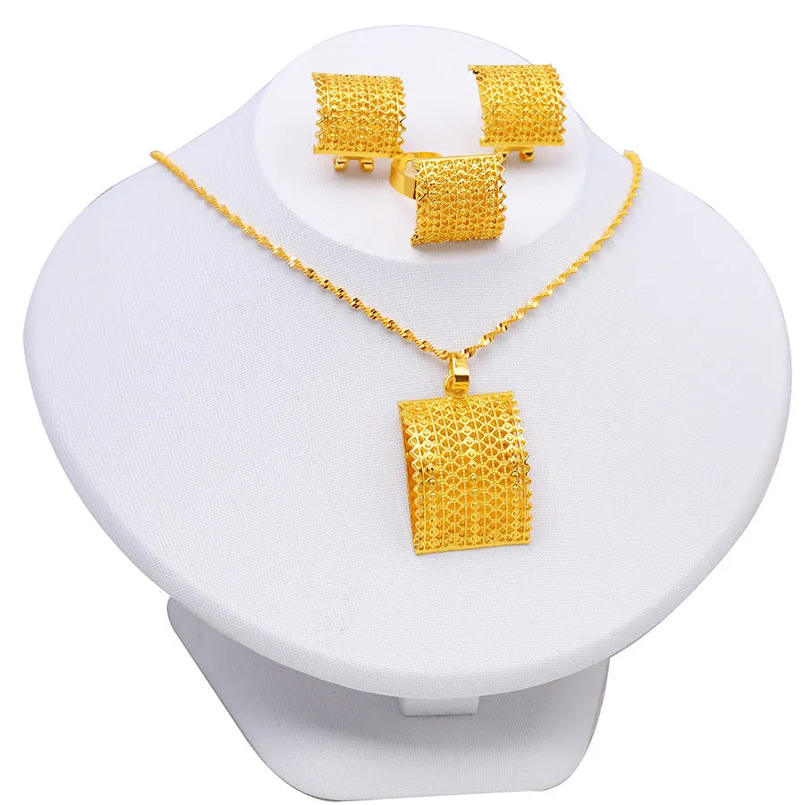 Golden copper bridal jewellery set featuring a necklace, pair of earrings, and a ring on a display.