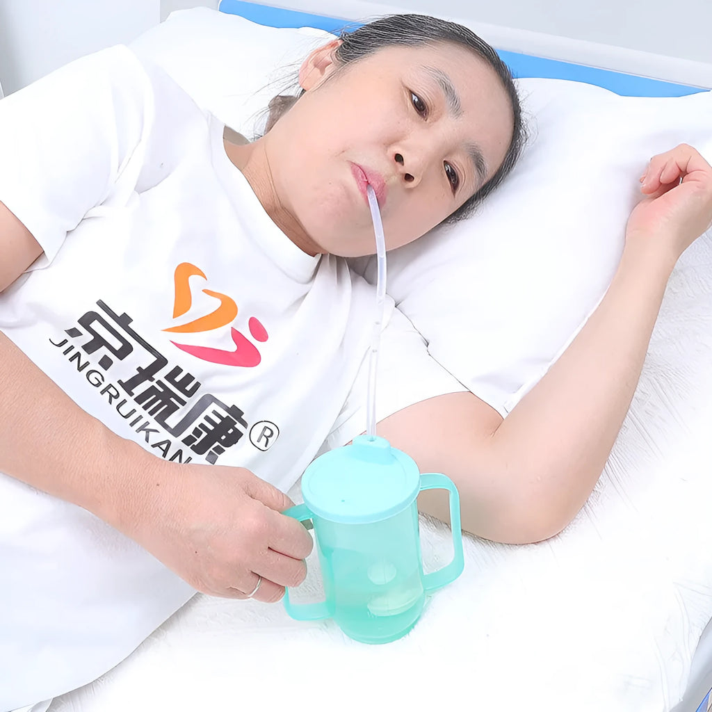 White PP plastic oblique mouth drinking cup with handle and lid for adult bedside use.