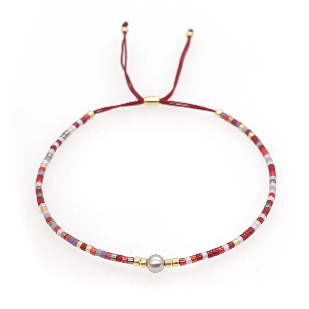 Close-up of a colourful Bohemian-style beaded bracelet featuring semi-precious stone and glass beads on a wrist.