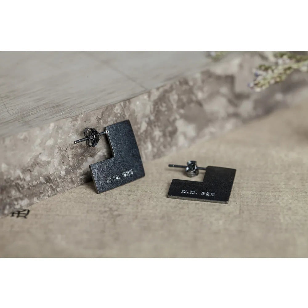 Close-up of a pair of oxidation black geometric square stud earrings made from 925 sterling silver.