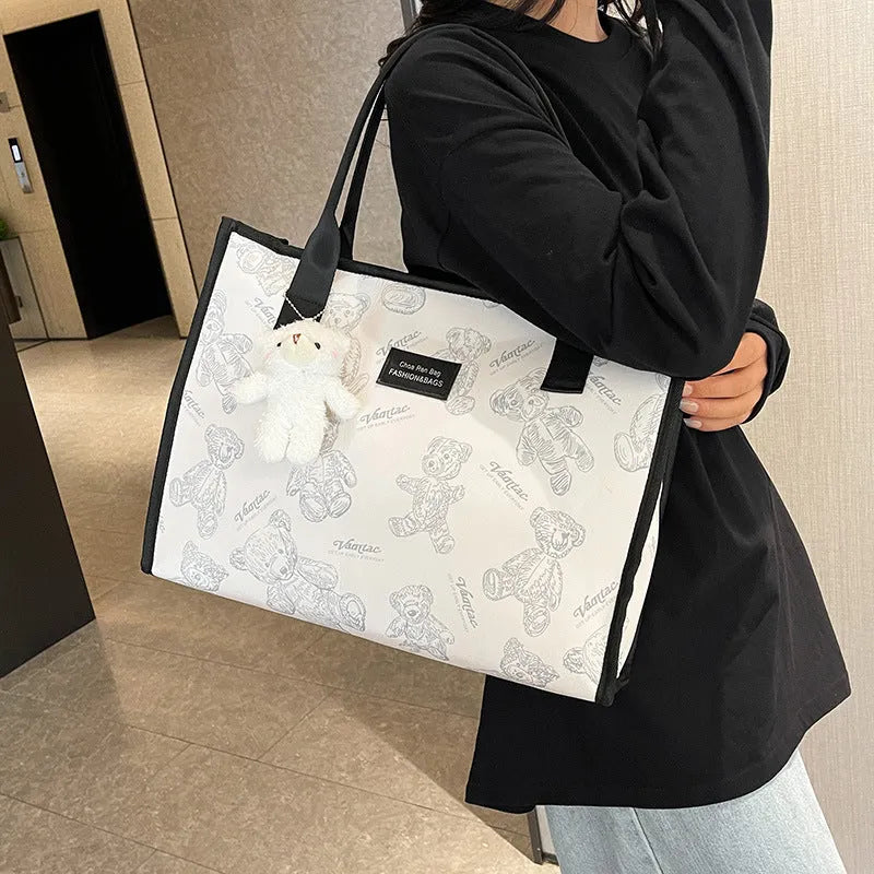Women's black and white rhombus pattern canvas tote bag with shoulder strap showing horizontal square shape