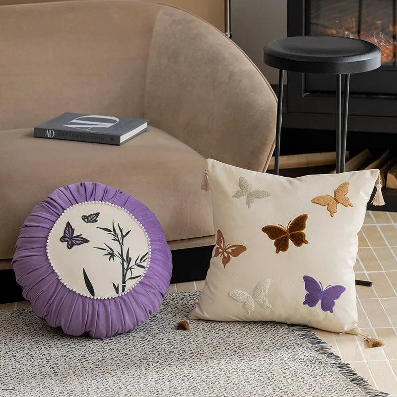 Square beige cushion with detailed black butterfly embroidery in a Chinese style.
