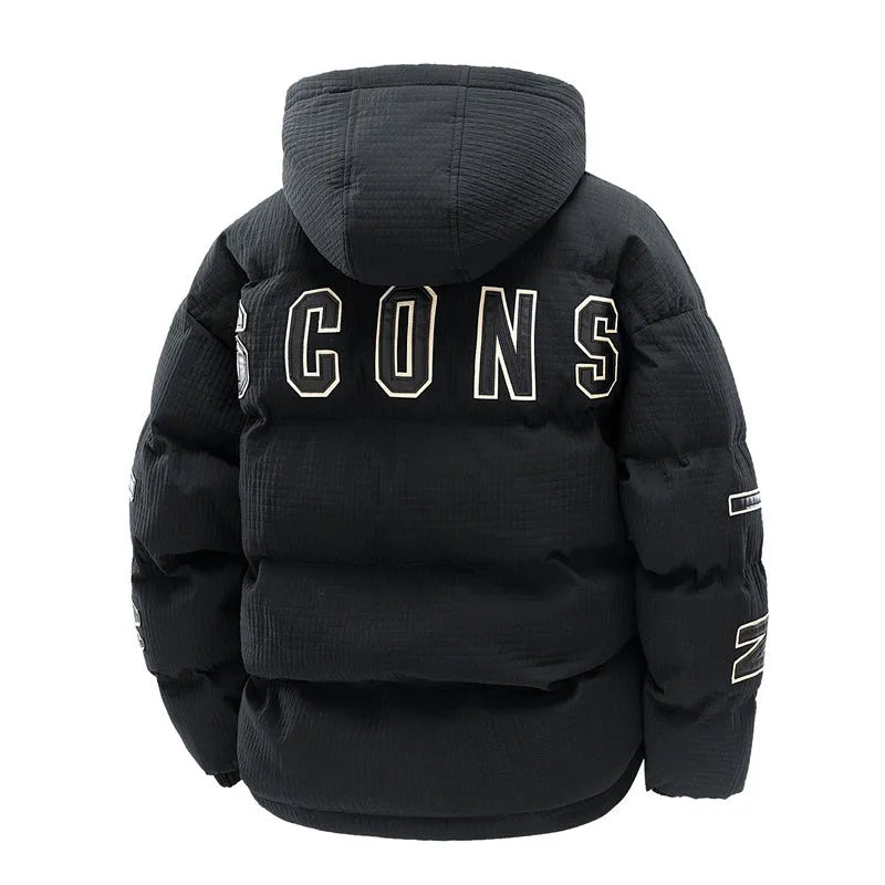 A man wearing a black hooded cotton-padded winter coat with letter-print detail and side pockets.