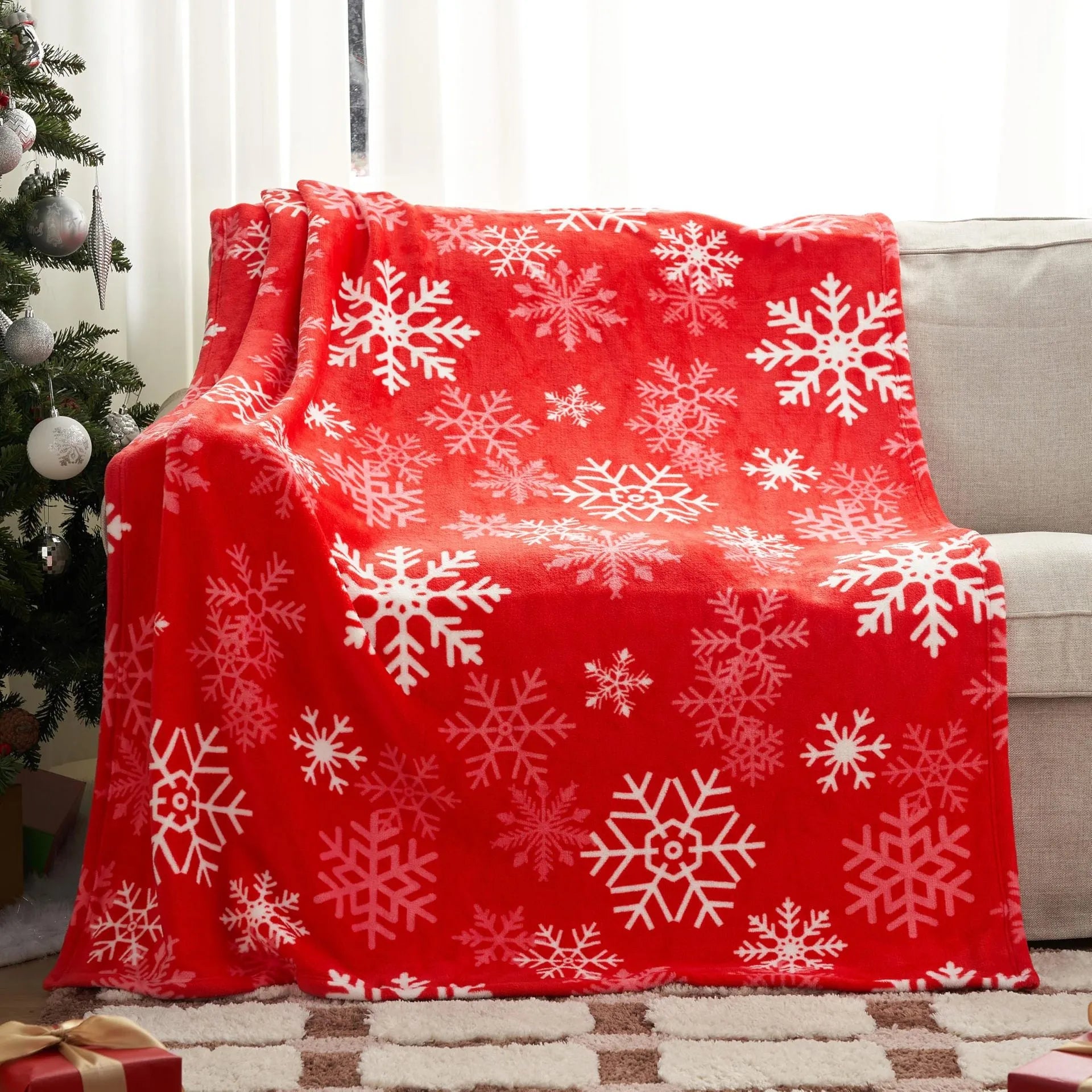 Soft red polyester flannel Christmas blanket folded on a bed