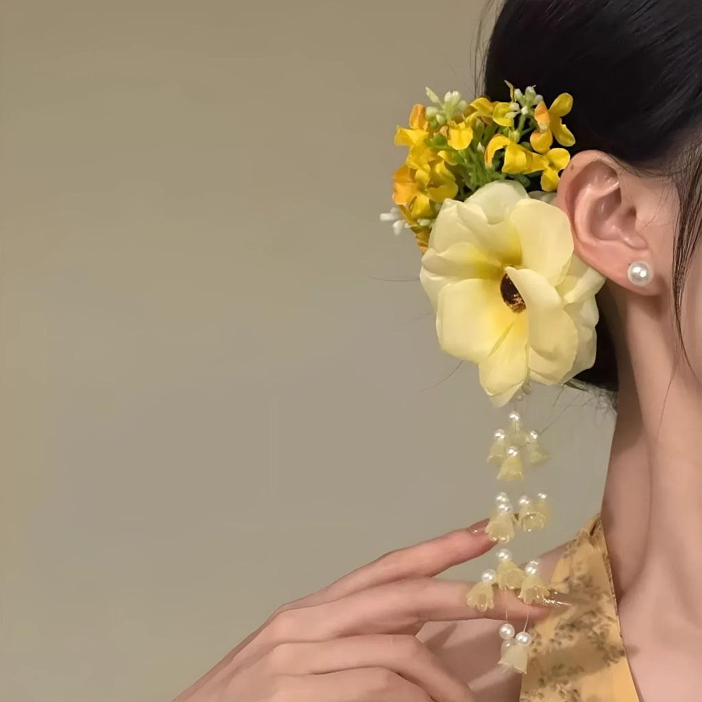 Close-up of a handcrafted women's hair clip with a flower tassel in purple and yellow colour options.